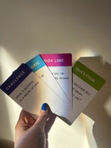 4 songwriting promt cards featuring an insightful question, song topic, hook line and inspiring song idea displayed by professional singer and songwriter.
