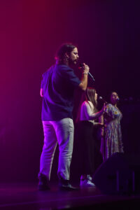 SoundCheck Studios singing student performing on stage in Ballarat with talented backup singers.