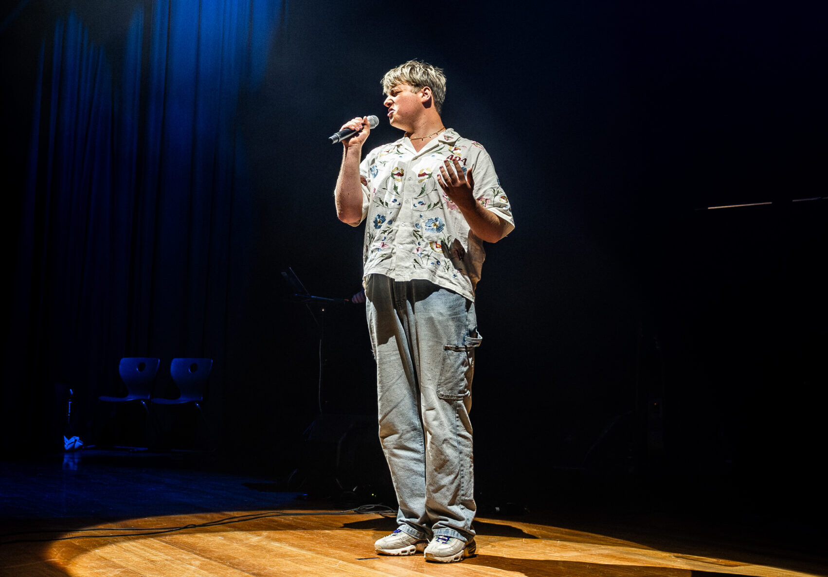 Young person confidently performs on stage at inclusive and supportive music studio